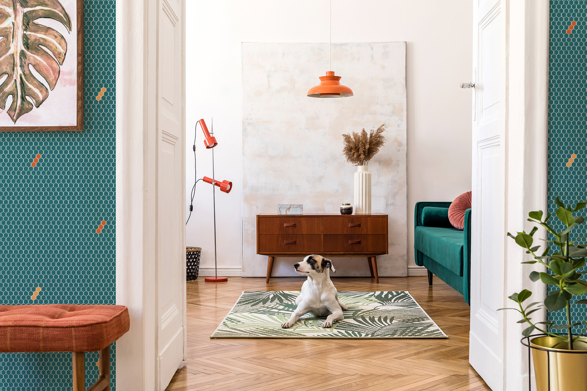 Stylish compositon of retro home interior with mock up poster frame, dog on the carpet, vintage furnitures, velvet sofa, design lamps, plants and elegant accessories. Nice home decor of living rooms.